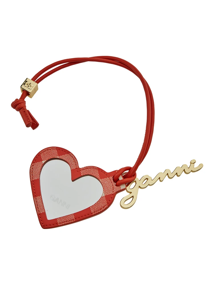 مرآة حمراء على شكل قلب مزينة بشعار مكتوب، مصنوعة من قماش تقني وجلد نسائي