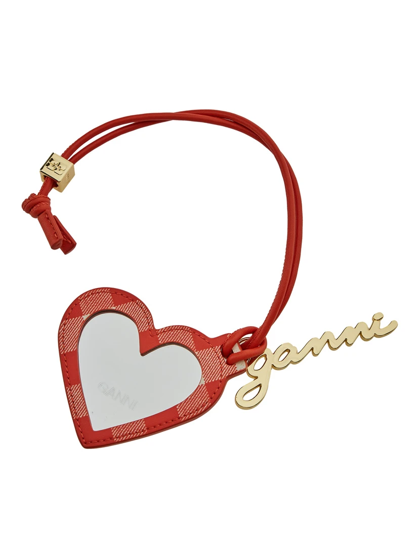 مرآة حمراء على شكل قلب مزينة بشعار مكتوب، مصنوعة من قماش تقني وجلد نسائي