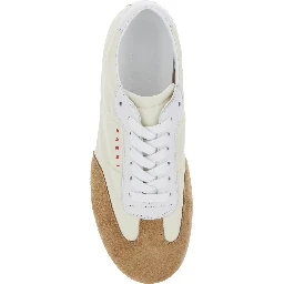 حذاء رياضي أبيض بتفاصيل من الجلد المدبوغ وشعار مكتوب من الجلد الصناعي للنساء