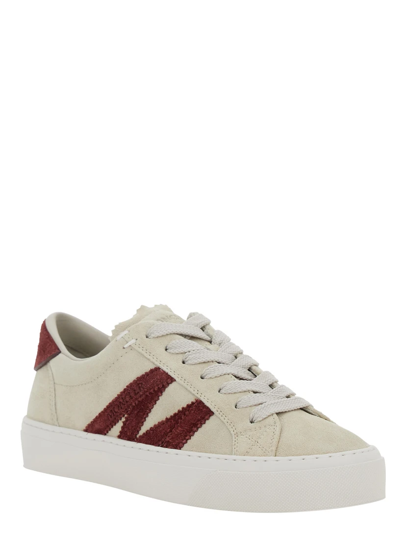 حذاء رياضي أبيض منخفض الرقبة مزين بشعار على الجانب ورقعة شعار على اللسان، مصنوع من الجلد، للنساء