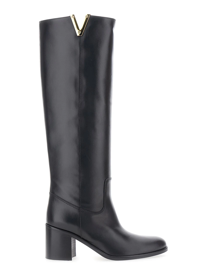حذاء أسود يصل إلى الركبة، مزين بفتحة جانبية وشعار من الجلد، للنساء