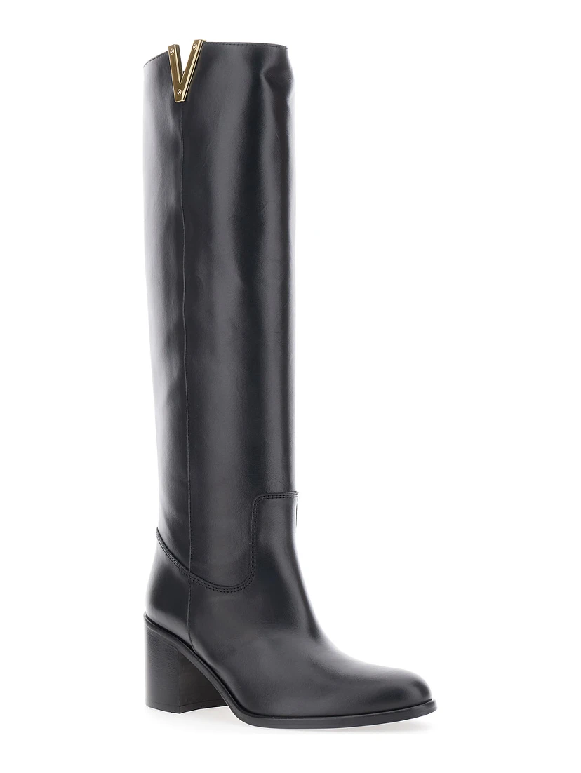 حذاء أسود يصل إلى الركبة، مزين بفتحة جانبية وشعار من الجلد، للنساء