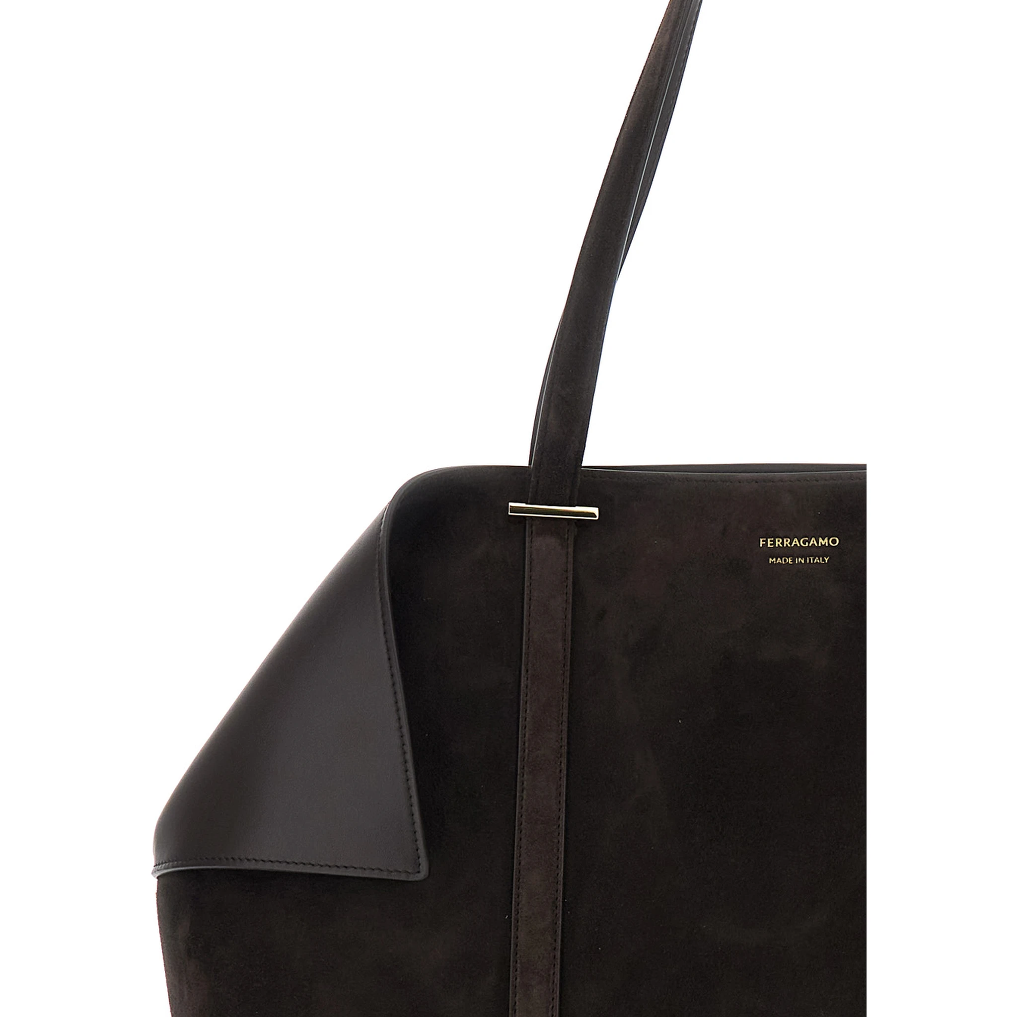 حقيبة يد بنية اللون بتصميم زوايا مطوية وشعار بارز في الأمام، مصنوعة من جلد الغزال، للنساء