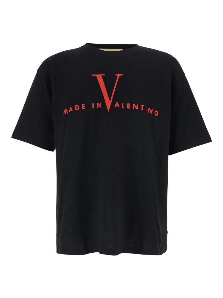 تيشيرت أسود برقبة دائرية وشعار مطبوع على الجهة الأمامية وأكتاف منسدلة، مصنوع من القطن الرجالي